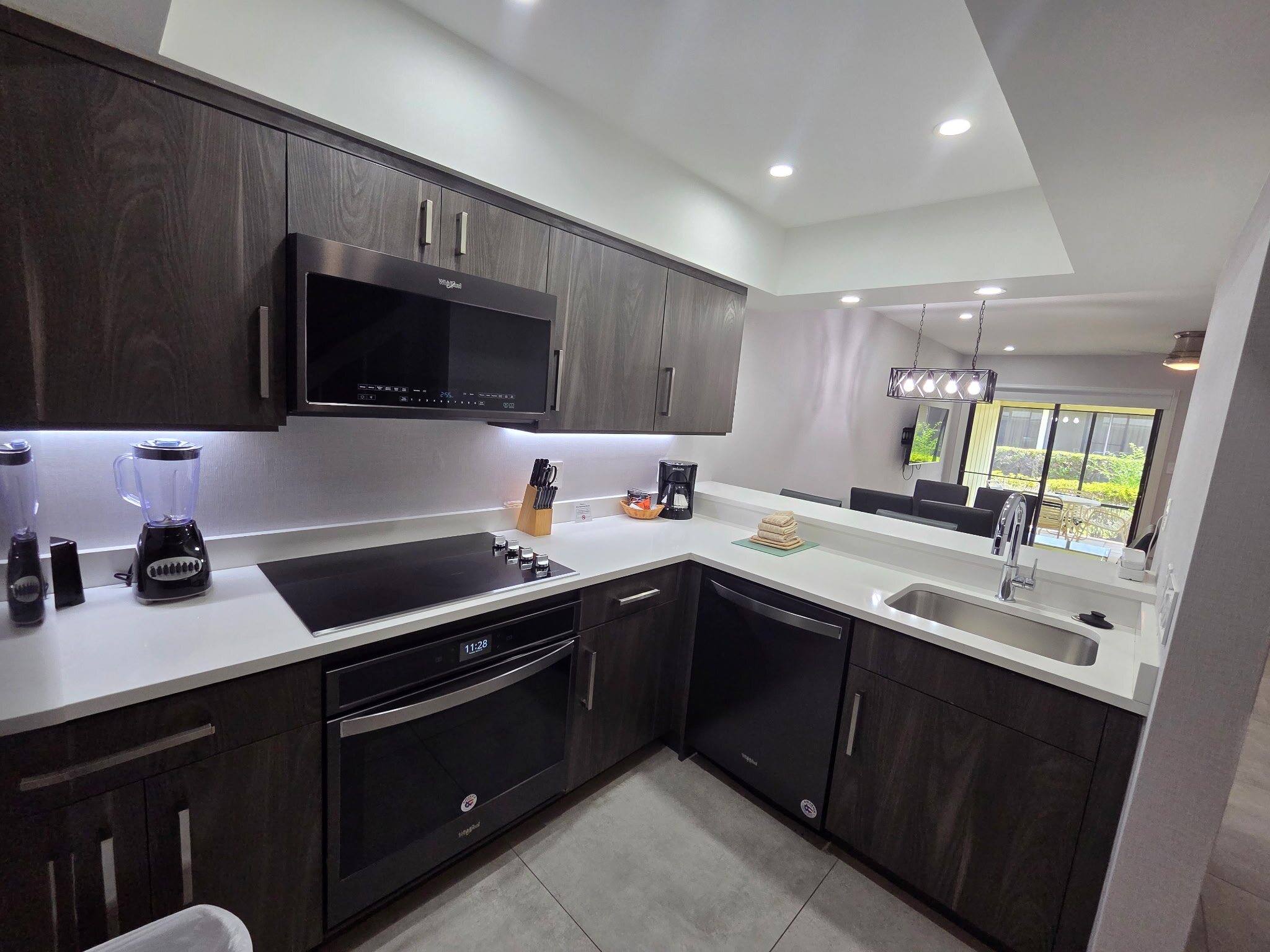Deluxe Townhouse kitchen with a cooktop, wall oven and dishwasher, looking through to the dining area