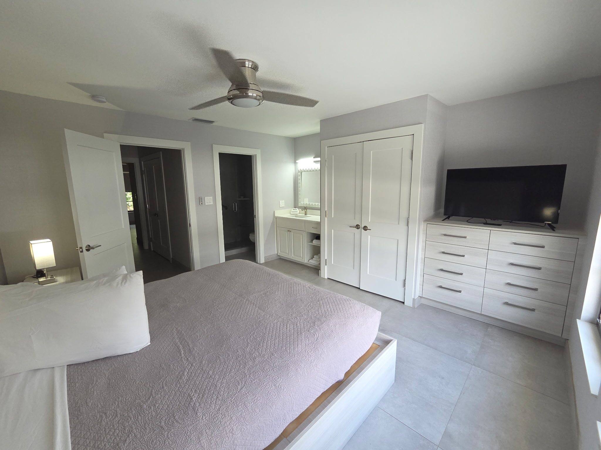Deluxe Townhouse primary bedroom with a king bed facing a dresser, TV and double closet