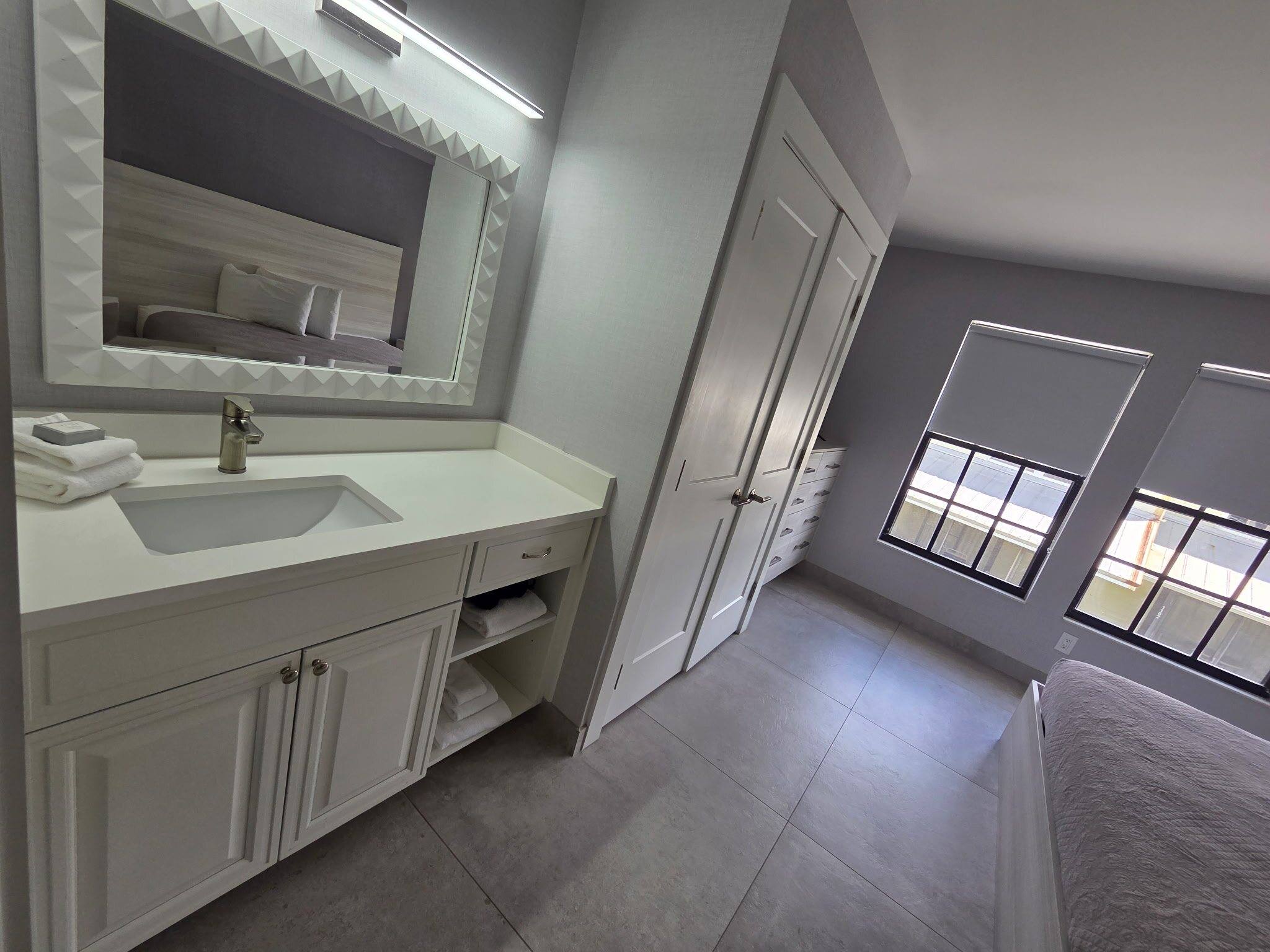 Vanity with a large mirror and sink in the Deluxe Townhouse primary bedroom