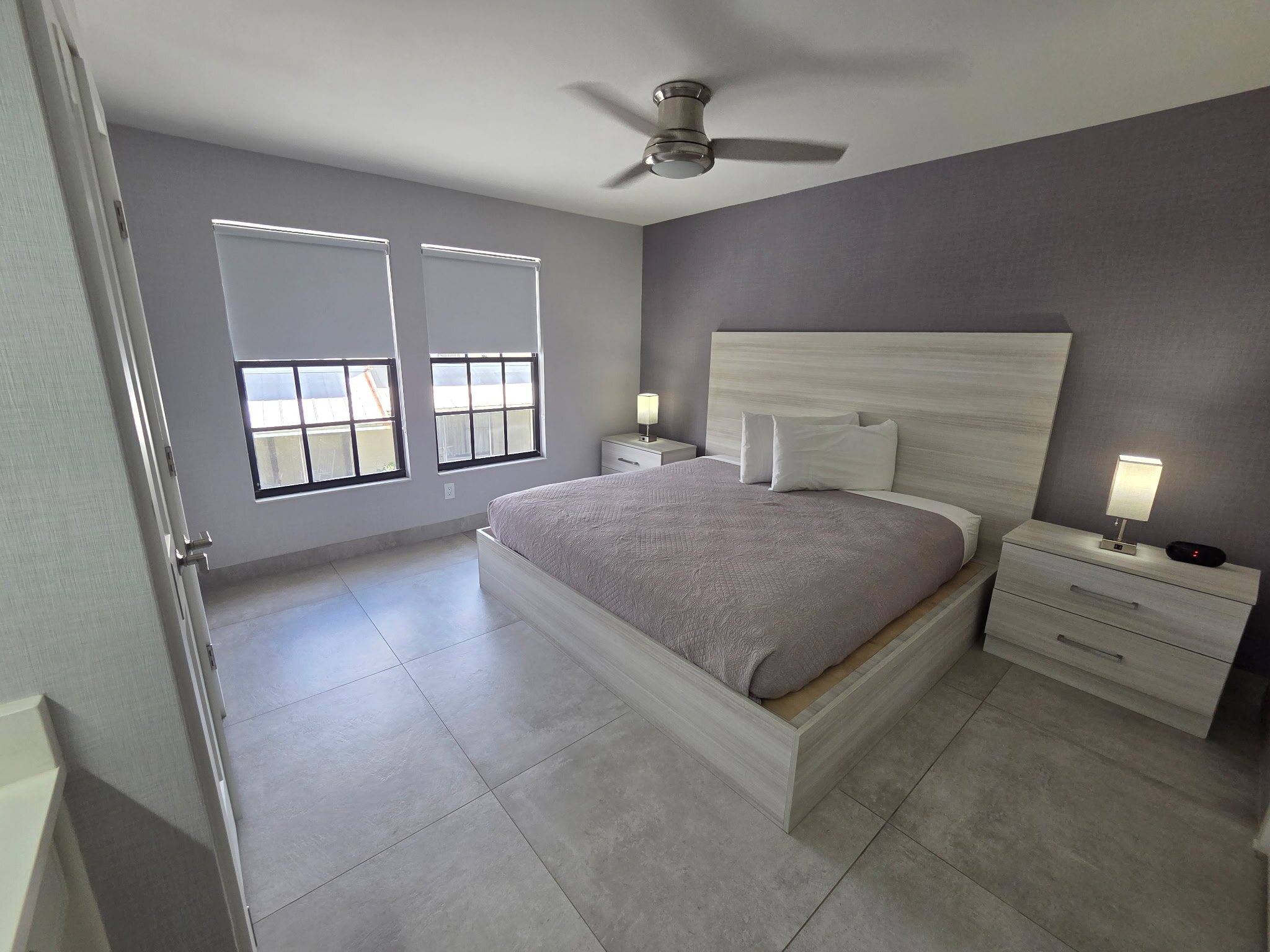 Deluxe Townhouse primary bedroom with a king bed, nightstands and two windows