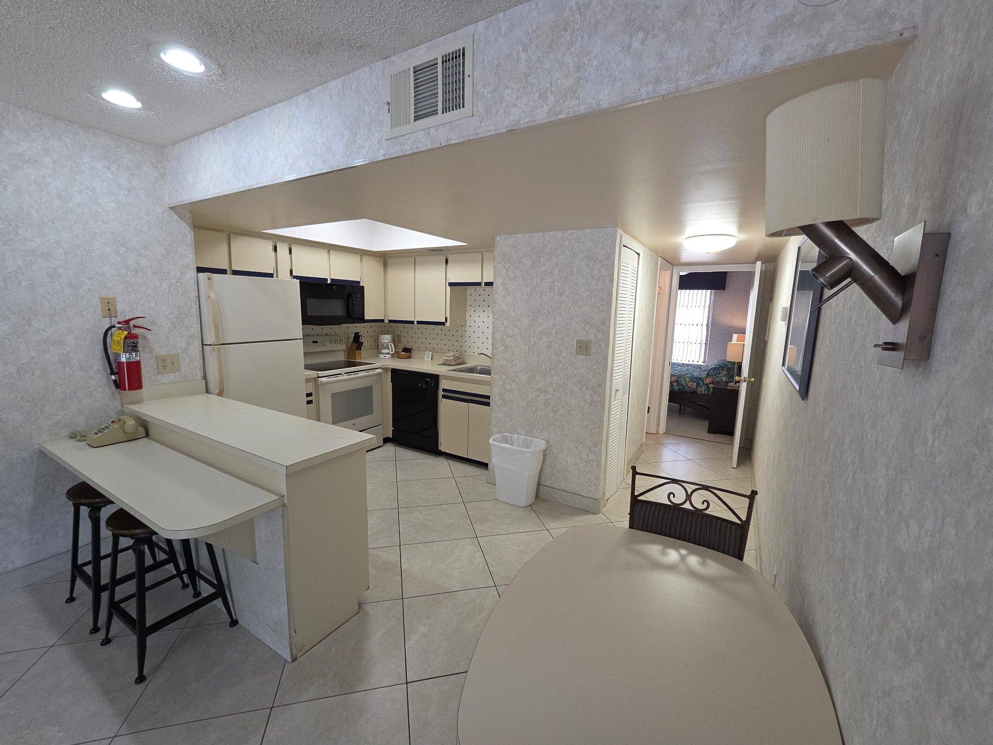Villa kitchen with white cabinets and a breakfast counter with two stools